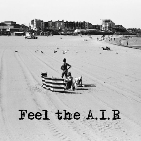 Black and white beach scene with two people and text 'Feel the A.I.R'.