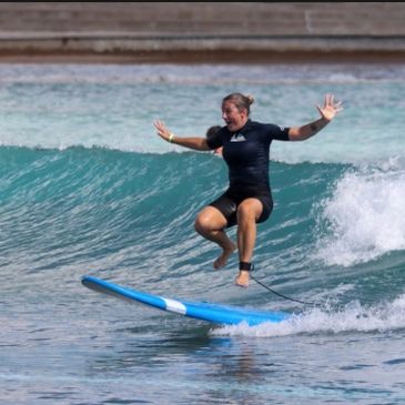 Person balancing on a surfboard on a wave.