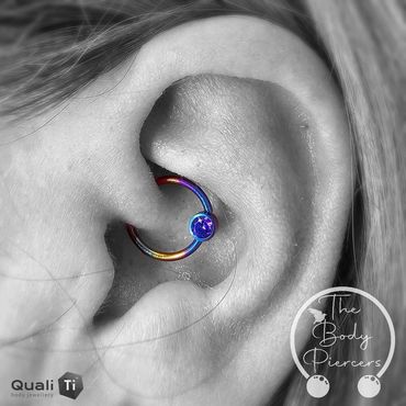Black and white photo Ear piercing BCR ball closure ring anodised multicolour blues yellows purples