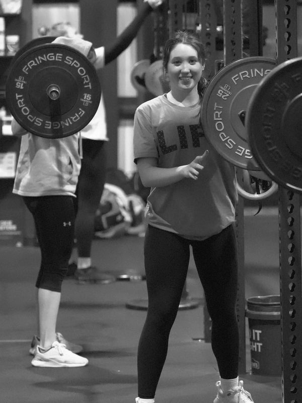 Young woman weightlifting at a gym.