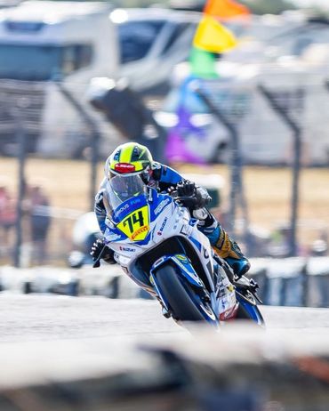 Motorcycle racer leaning into a curve during a race.