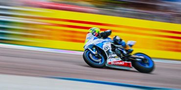 Motorcycle racing at high speed on a track.