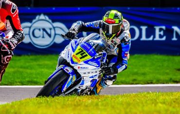 Motorcycle racer leaning into a turn on a racetrack.