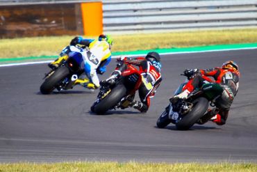 Three motorcyclists racing on a track.