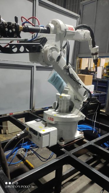 Industrial ABB robotic arm in a factory setting.