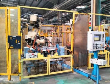 Industrial robotic arm inside safety enclosure.