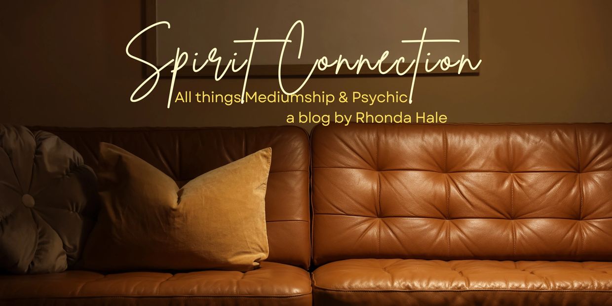Cozy brown leather couch with pillows under a sign reading 'Spirit Connection'.
