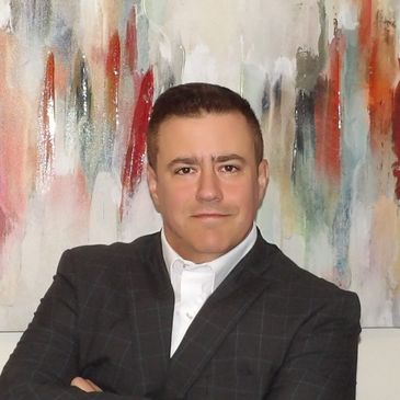 Company President wearing an expensive suit in front of a painting.