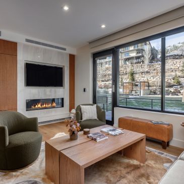 Cozy modern living room with fireplace and large windows.