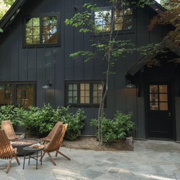 Cozy outdoor seating area in front of a dark house.