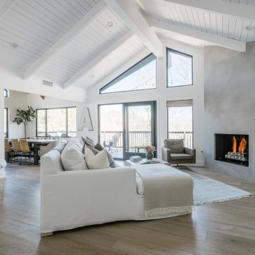 Bright modern living room with white sofa and fireplace.