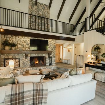 Cozy living room with stone fireplace and loft interior.
