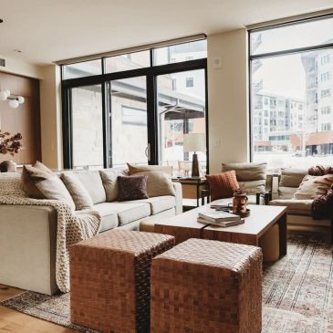Cozy modern living room with neutral tones and woven ottomans.