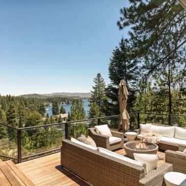 Cozy outdoor deck with lake and forest view.