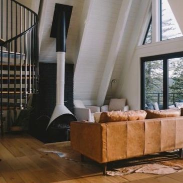 Cozy living room with leather sofa and spiral staircase.