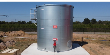 Blue Tank fire protection water tank labeled FDC on a concrete base outdoors. This tank represents commercial fire protection water tank installation by Lone Star Water Experts, supporting fire suppression systems, reliable water storage solutions, and residential fire protection water tank maintenance.