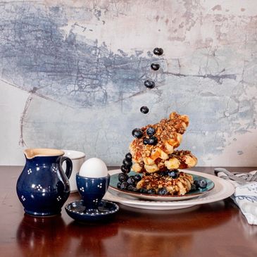 Our waffles topped with pecan praline syrup and blueberries!  Served in dishware from Soufflenheim, 