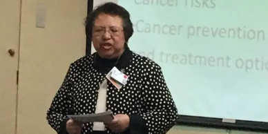 A woman giving a presentation about cancer risks and prevention.