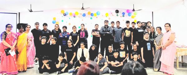 Group photo of young people and teachers in a decorated room.