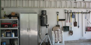 Garage wall with organized tools hanging on the walls and neatly on shelves