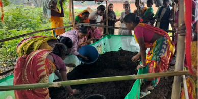 Women working together on a composting project under a shelter.