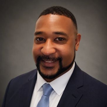Professional headshot of a smiling man in a suit.
