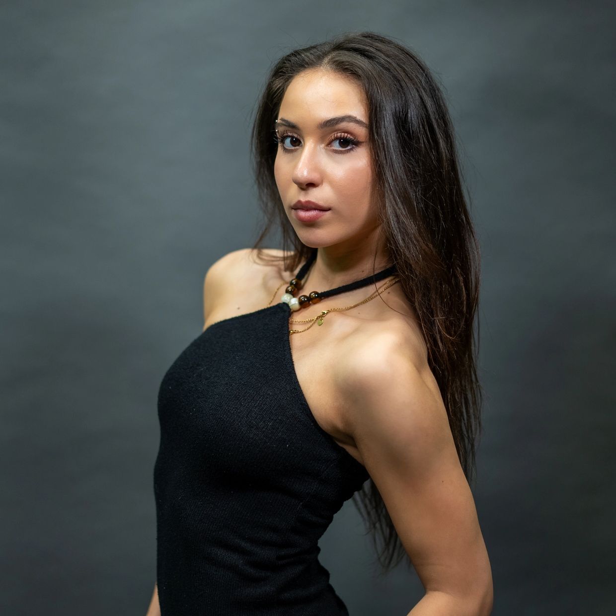 Woman posing confidently in a black halter top.