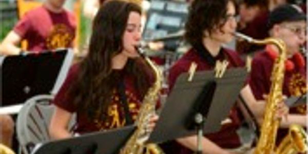 Students play saxophones in a school band.