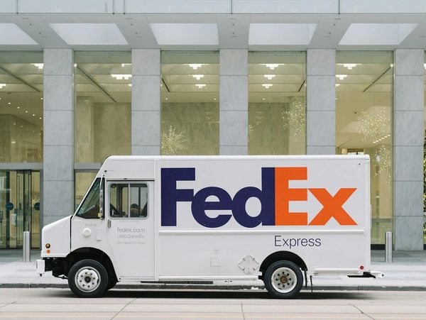 FedEx Express delivery truck parked in front of a modern building.