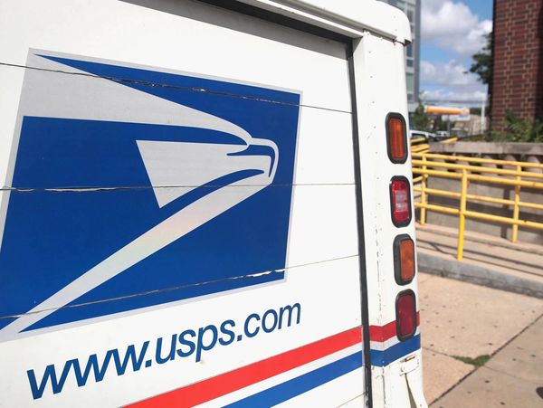 Close-up of a USPS logo on the side of a mail delivery truck.