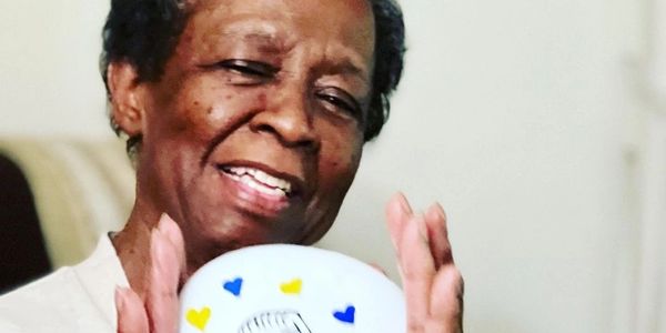 Mama holding up a ceramic art piece.