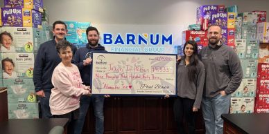 Group of six holding a large donation check.