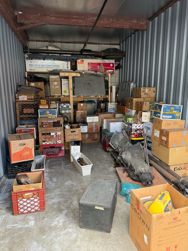 A storage unit filled with various boxes and automotive parts.