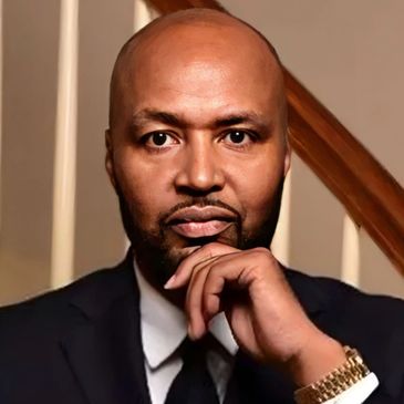 Portrait of a thoughtful man in a suit with a gold watch.