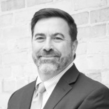 Professional man in a suit smiling.