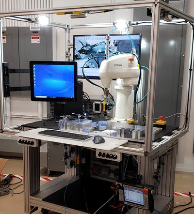Lab setup with robotic arm and computer screens.