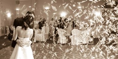 Couple sharing a dance amidst falling confetti.