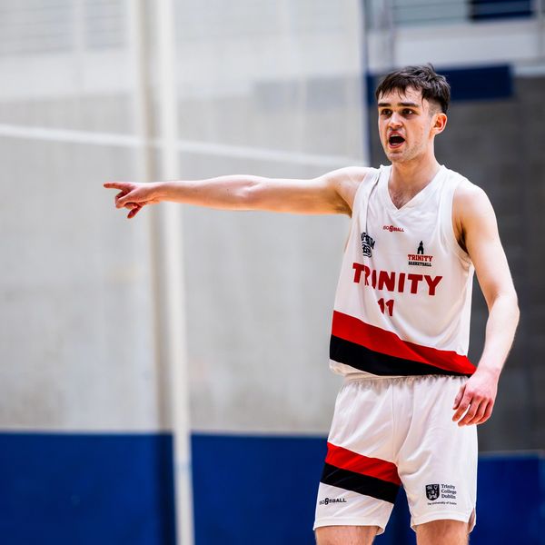 Basketball player from Trinity team directing on court.