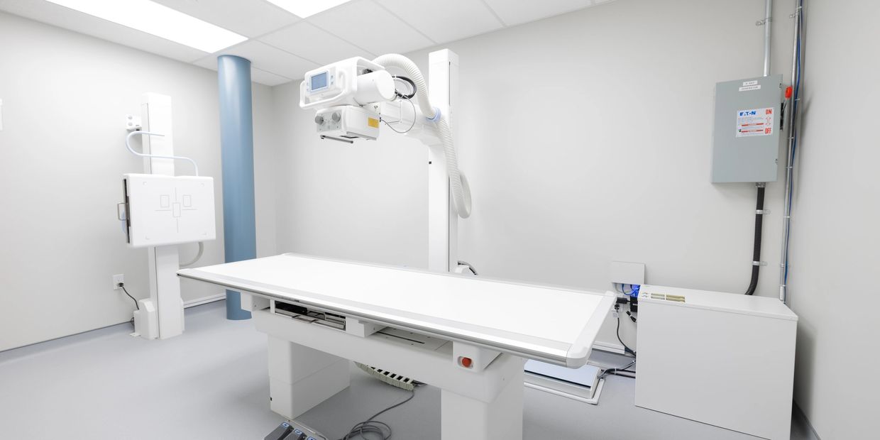 Modern X-ray room with clean, white equipment and bright lighting.