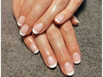 Classic French manicure on well-groomed hands.