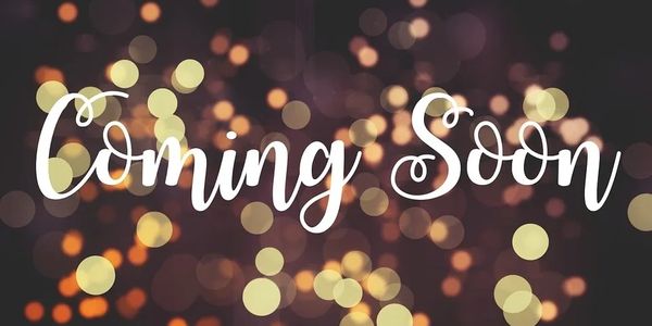 Elegant 'Coming Soon' text with blurred glowing lights background.