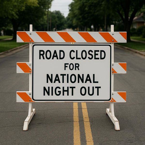 Road closed sign for National Night Out event blocking the street.