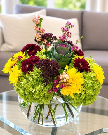 Colorful flower bouquet in a glass vase on a table.