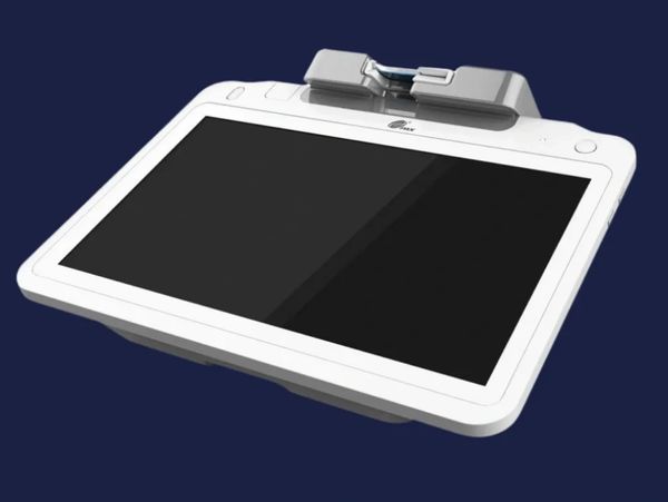 A white electronic device with a large screen and a top attachment against a dark background.