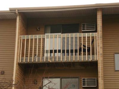 Apartment balcony with white railing.