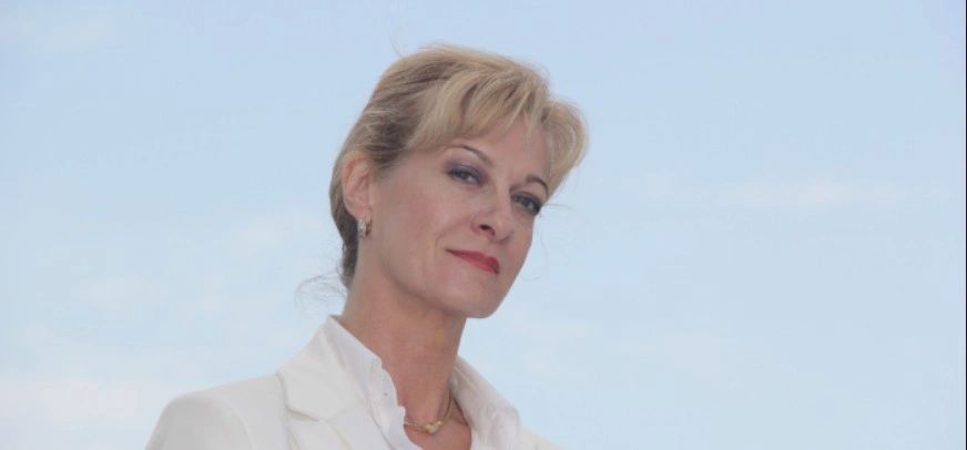 Confident woman in a white suit against a clear blue sky classy and elegant.