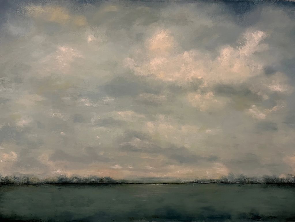 A tranquil landscape with a cloudy sky over a calm body of water.