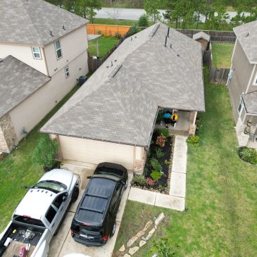A suburban house with two cars parked in the driveway.