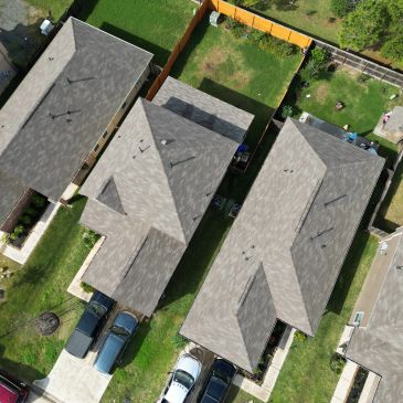 Aerial view of suburban houses and parked cars.
