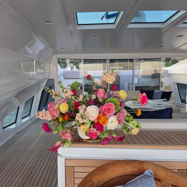 Vibrant floral arrangement on a polished yacht deck under skylights.